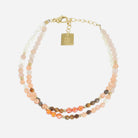 Double-row bracelet of small peach, sand and brown stones on gold, with an engraved gold tag