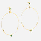 Pair of large fine gold hoop earrings set with small green stones along one side