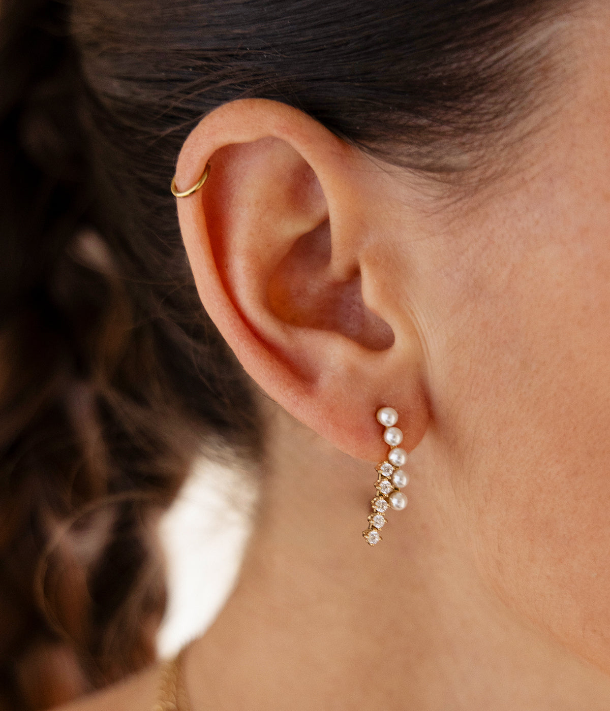 Model wearing the pearl and crystal drop earring, hair swept back off the ear