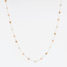 Fine gold chain necklace with small peach and sand coloured stones spaced along it