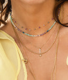 Model wearing the stone necklace layered with other fine gold chains