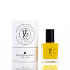 The Perfume Oil Company white gift cylinder beside a 10 ml bottle of deep amber-gold perfume oil
