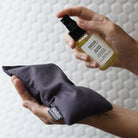 Spraying Salus Relaxing Sleep Mist over a charcoal Salus eye pillow