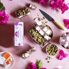 Pebbly Path Turkish Trail rocky road 100 g box with cut slices, pistachios, marshmallows, Turkish delight and pink bougainvillea, seen from above