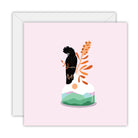 Square pale pink card with a red-tailed black cockatoo on a vase of orange banksia with green hills painted inside, on a white envelope