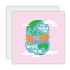 Square pink card with arms hugging the Earth among white clouds, lettered you mean the world to me, on a white envelope