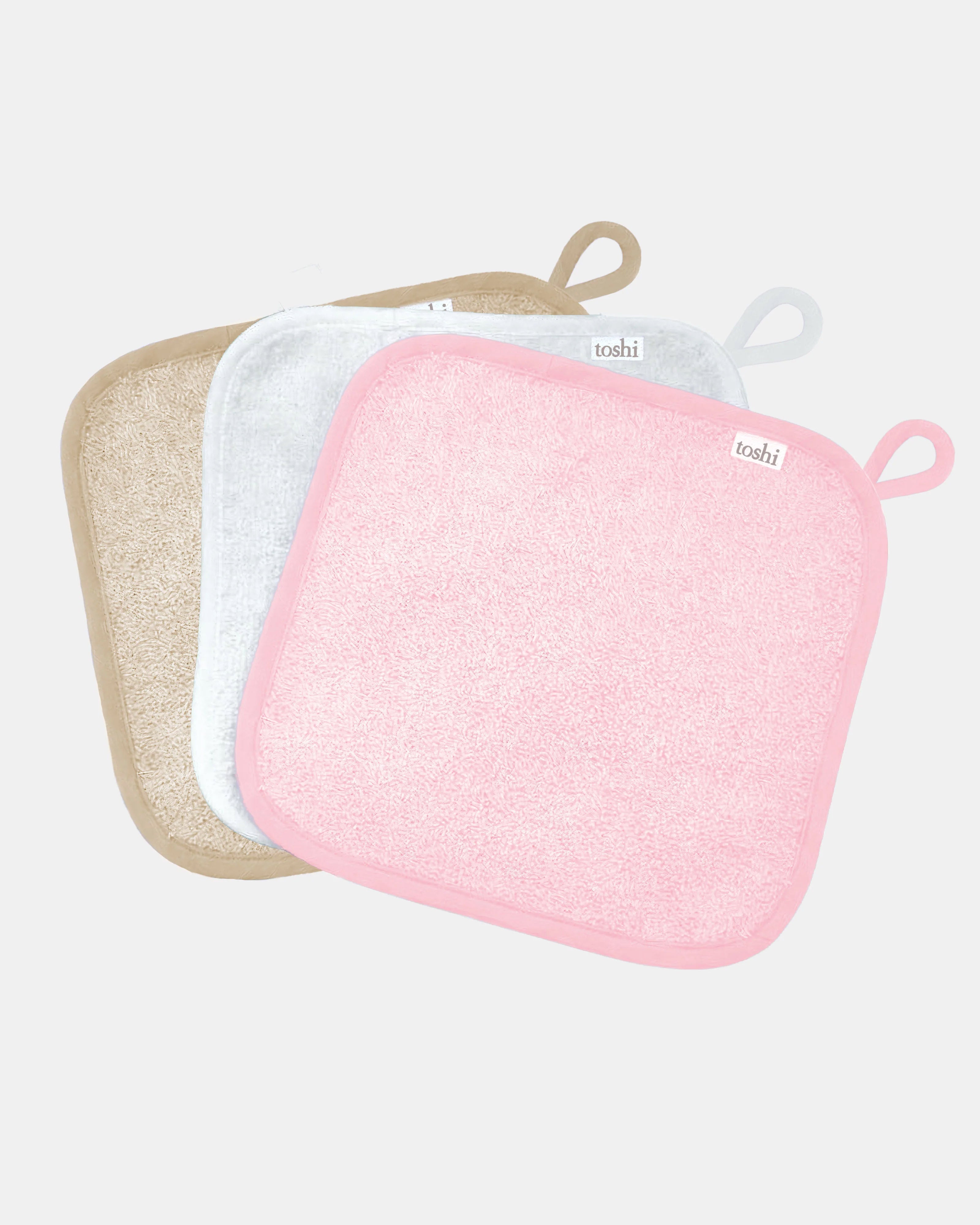 Three Toshi baby washcloths in pink, white and sand cotton towelling, each with a hanging loop
