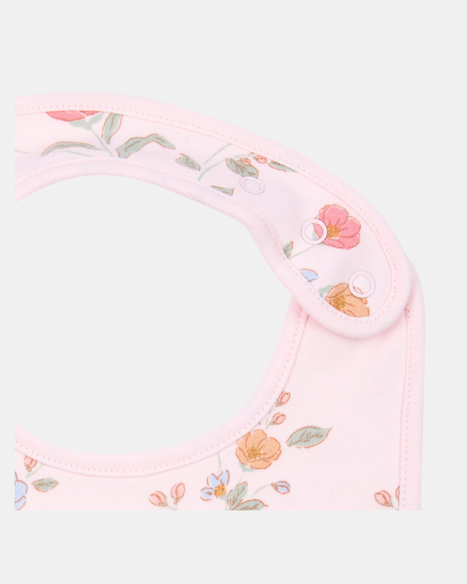 Close-up of the bib's adjustable press studs and neat pink bound edging