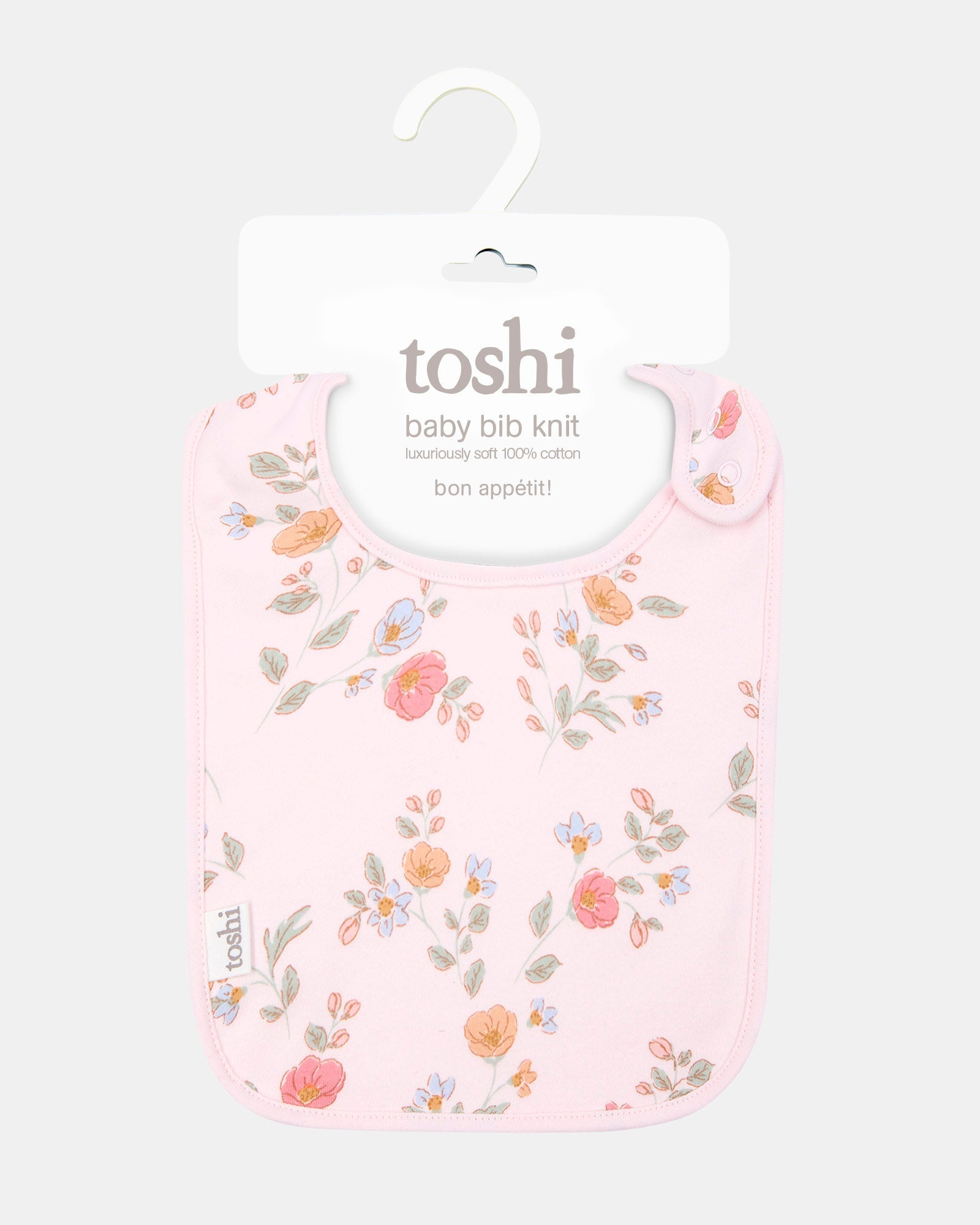 The bib on its Toshi hanging card, labelled baby bib knit in 100% cotton