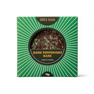 Front of the green sunburst dark peppermint bark box, the bark visible through the round window
