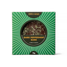 Front of the green sunburst dark peppermint bark box, the bark visible through the round window
