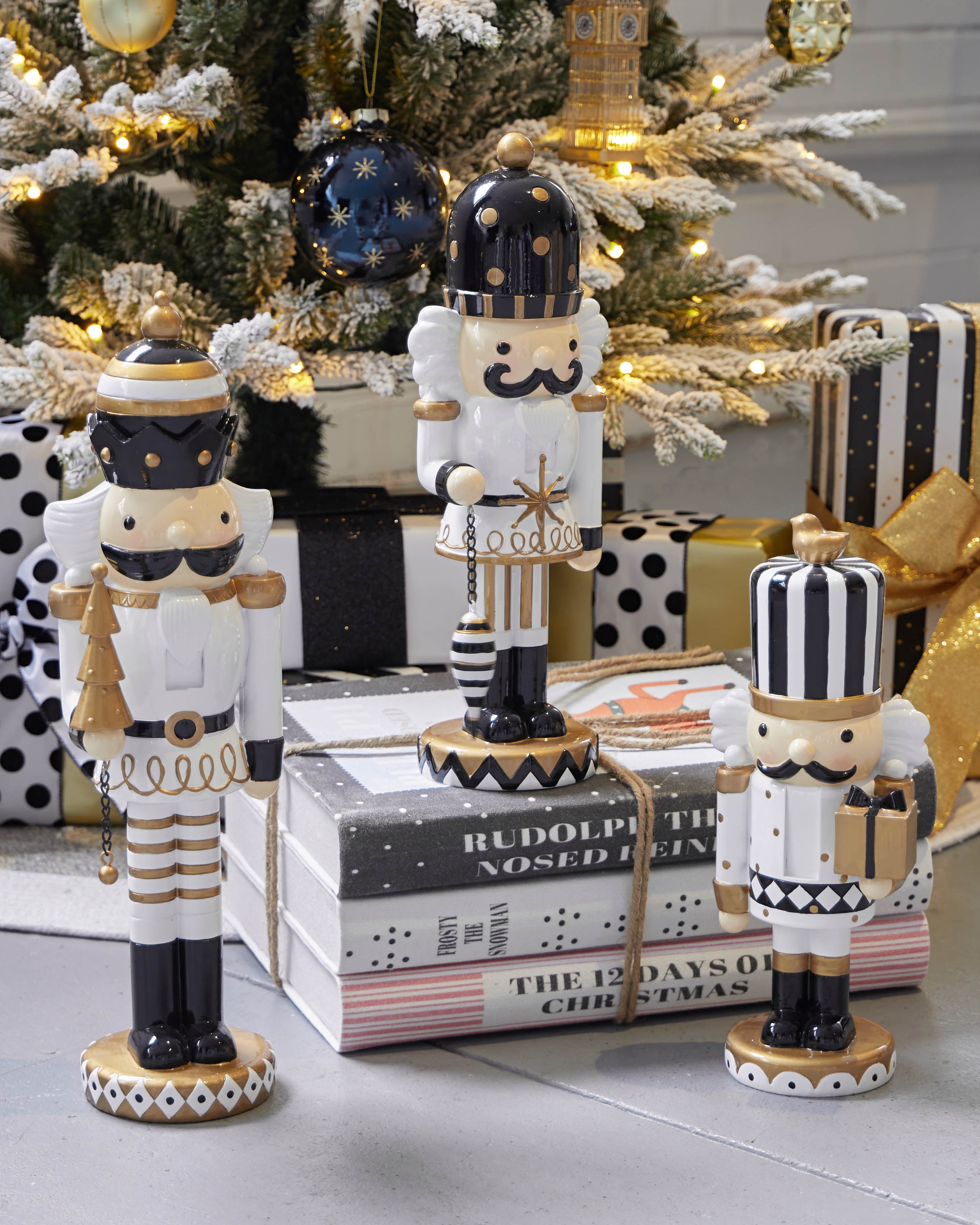 The Christmas book stack styled under a decorated tree with black and white nutcrackers