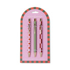 Three ballpoint pens, pink and red diamond, sage green and pink and burgundy check, clipped to an arched pink card