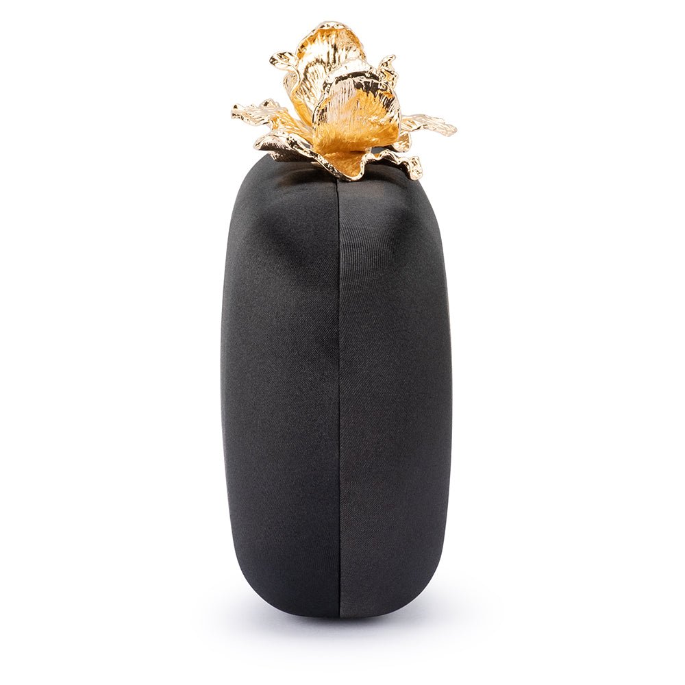 End view of the rounded black clutch with the orchid clasp on top