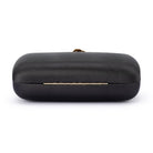 Back of the black satin clutch, a slim gold hinge along the seam
