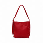 The red shoulder bag square on, showing the curved seam that forms its front pocket.