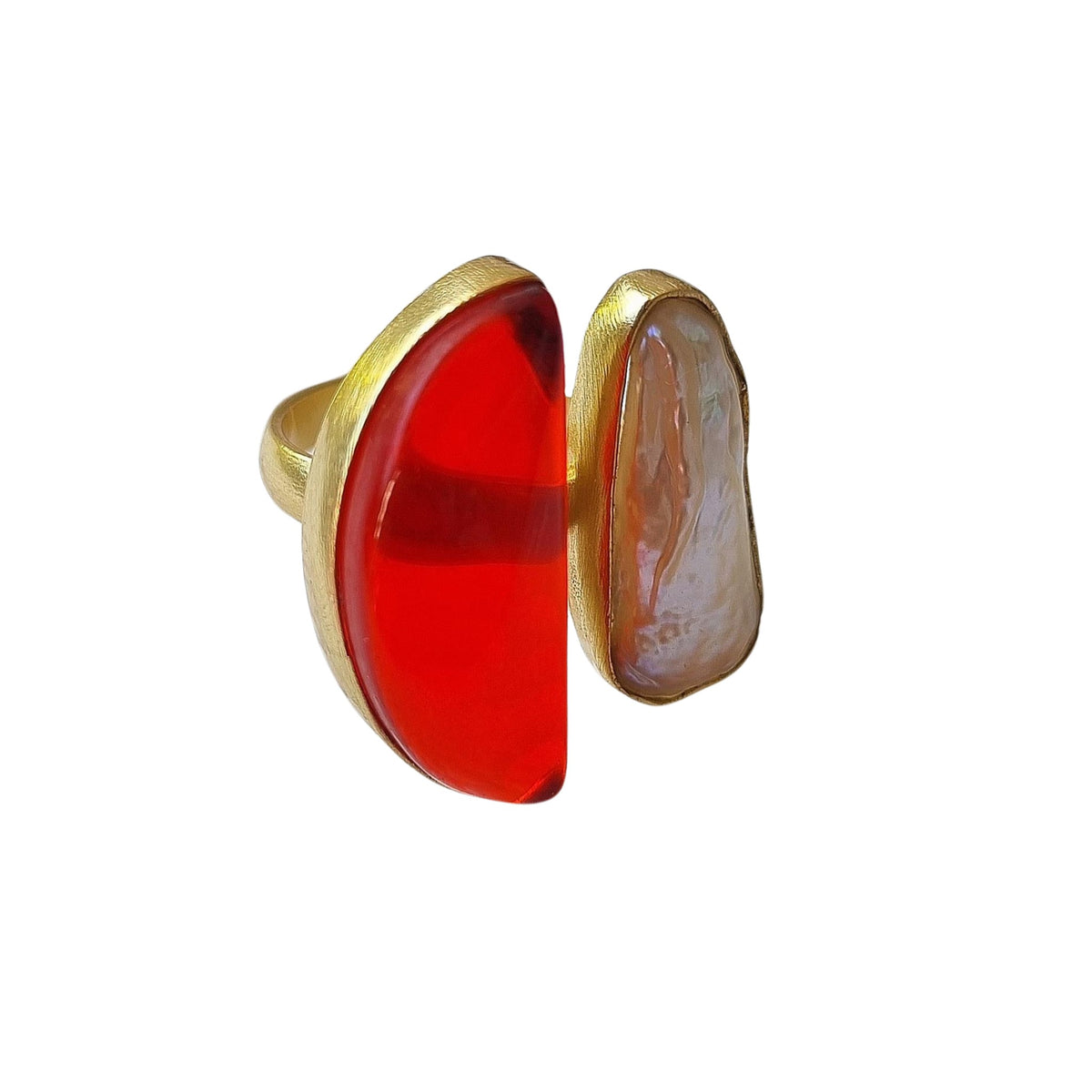 Gold-tone ring set with a translucent orange half-moon stone beside a pale pearl-look stone.