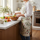 Australian Flora and Fauna apron worn in a kitchen while tossing a salad