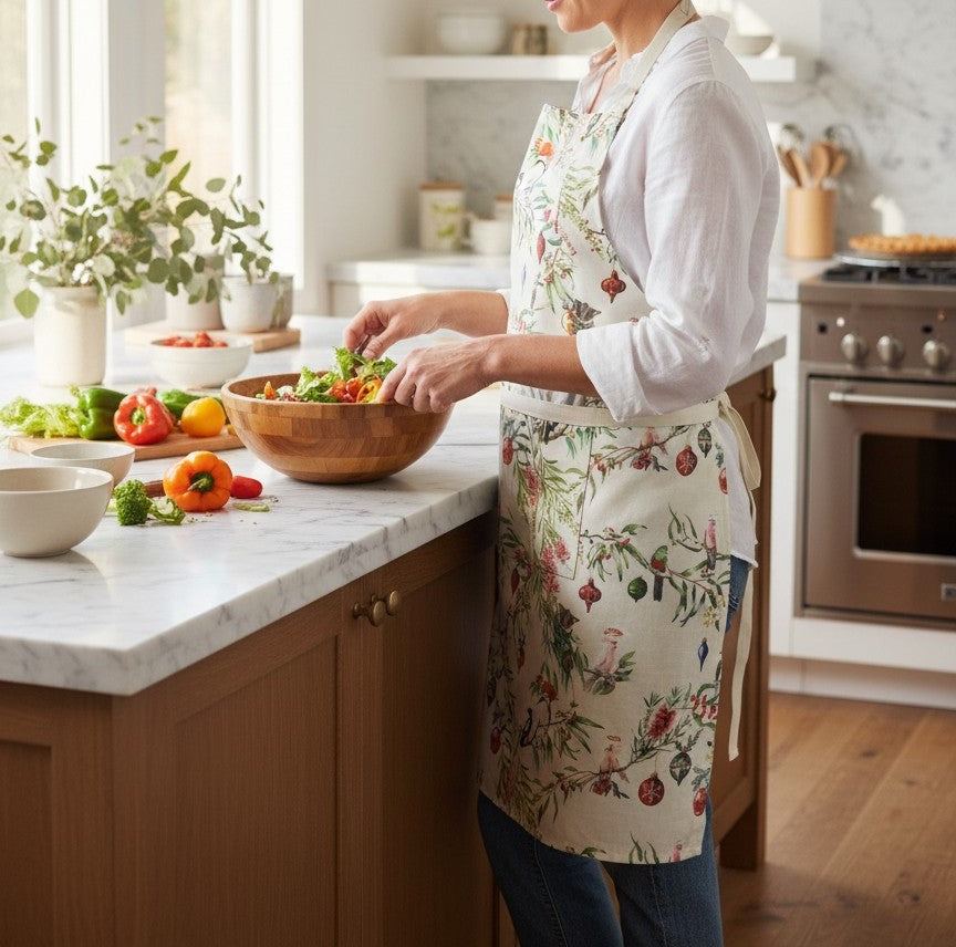 Australian Flora and Fauna apron worn in a kitchen while tossing a salad