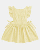 Back of the lemon Florence pinafore showing the frilled straps, the fastening down the back and the side ties