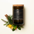Barber Shop soy candle in a cork-topped reclaimed wine bottle with cinnamon sticks, greenery and citrus peel