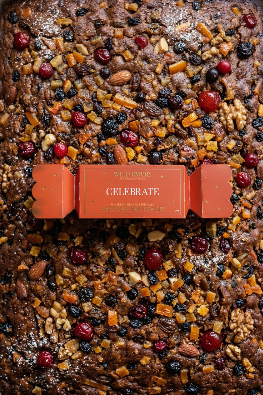 The Celebrate bon bon on top of a fruit cake studded with nuts and cherries.