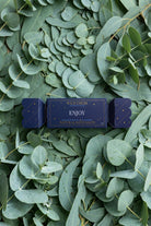 The Enjoy bon bon on a bed of eucalyptus leaves.