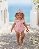 Toddler walking down a sunny lane in the Strawberry Fields sunhat and matching romper