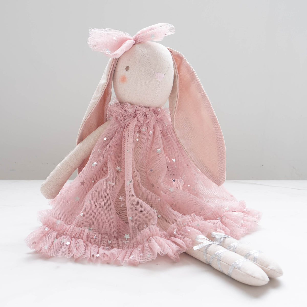 Belle bunny sitting side-on in her pink star tulle dress and ballet shoes.