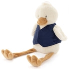 Cream plush duck with long dangly legs, sitting in a plain navy linen bib.