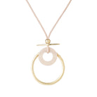 Blush cord necklace with a gold-tone ring and pale circle pendant