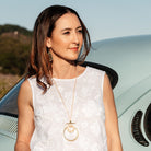 Belgium necklace in gold worn over a white top