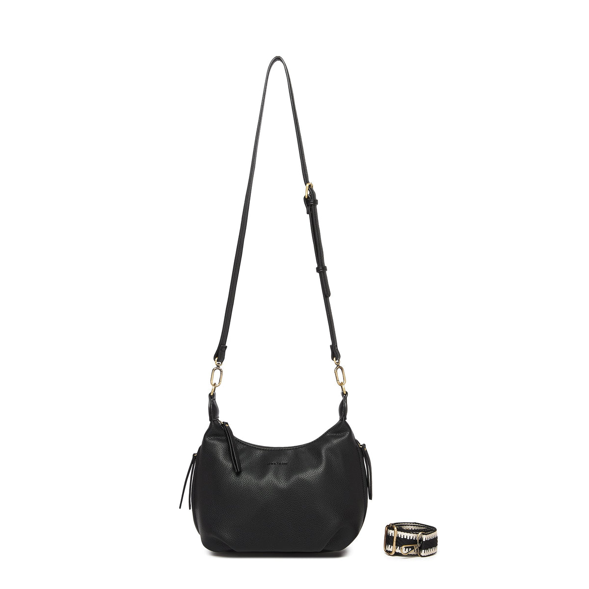The black bag on its long black cross body strap, with the patterned cotton strap coiled beside it.