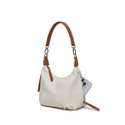 The white bag at an angle with a phone tucked into a side zip pocket.