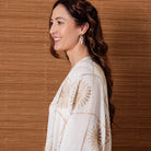 Side view of the white flower cover-up worn by a model