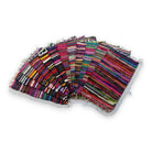 Ten handwoven chindi rugs fanned out in a stack, each a different mix of multicoloured recycled-fabric stripes with cream fringed ends, showing how much the colourways vary.