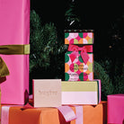 The Circles bon bon cleansing bar box and bar on wrapped presents under a Christmas tree.