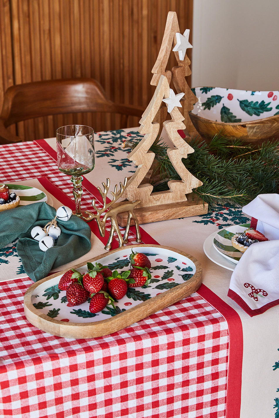 Christmas Foliage oval tray holding strawberries on a Christmas table, with the matching bowl behind