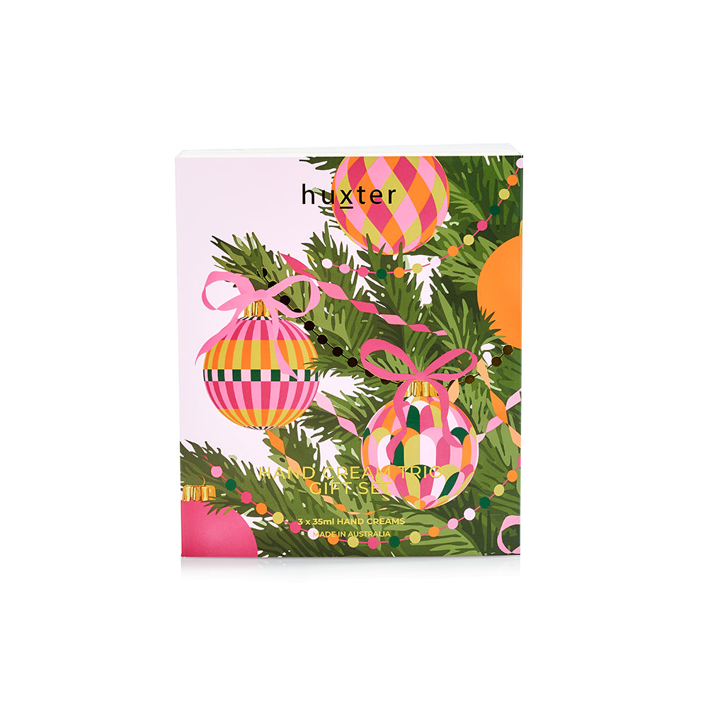 Lid of the Huxter Hand Cream Trio Gift Set, pink with Christmas baubles, pine and ribbon.