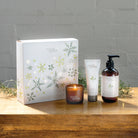 Myrtle & Moss Citrus Christmas gift box with the mini candle, 75 mL hand cream and 250 mL amber pump bottle of hand and body wash in front.
