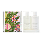 Huxter Christmas gift box printed with baubles and pine, beside a frosted wash bottle and a white lotion bottle on a white silicone tray.