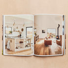 Cocoon open at a spread of a timber kitchen and a living room with a wood heater.