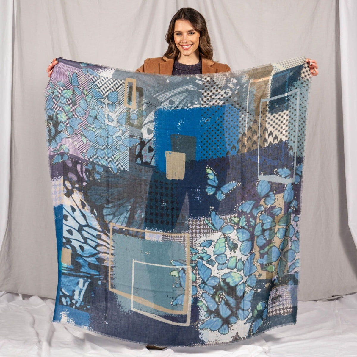 Model holding the square scarf open in front of her to show the full print