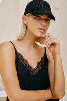 Model in a black lace-trimmed camisole wearing the Black crochet cap