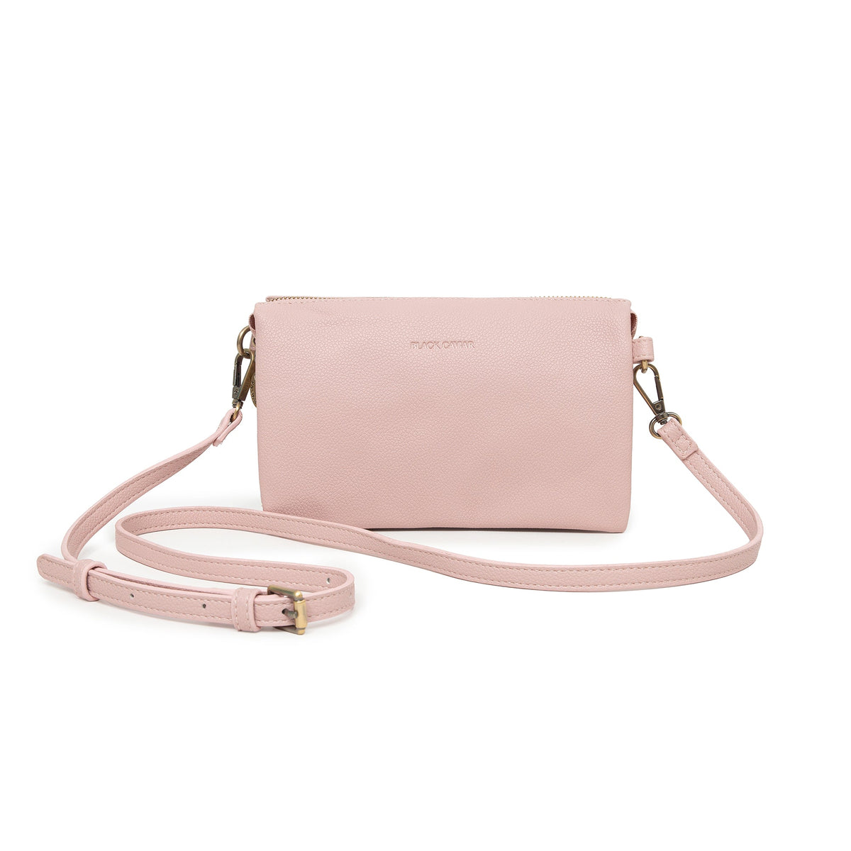 Pale pink cross body bag with gold-tone clips and a slim strap laid around it.