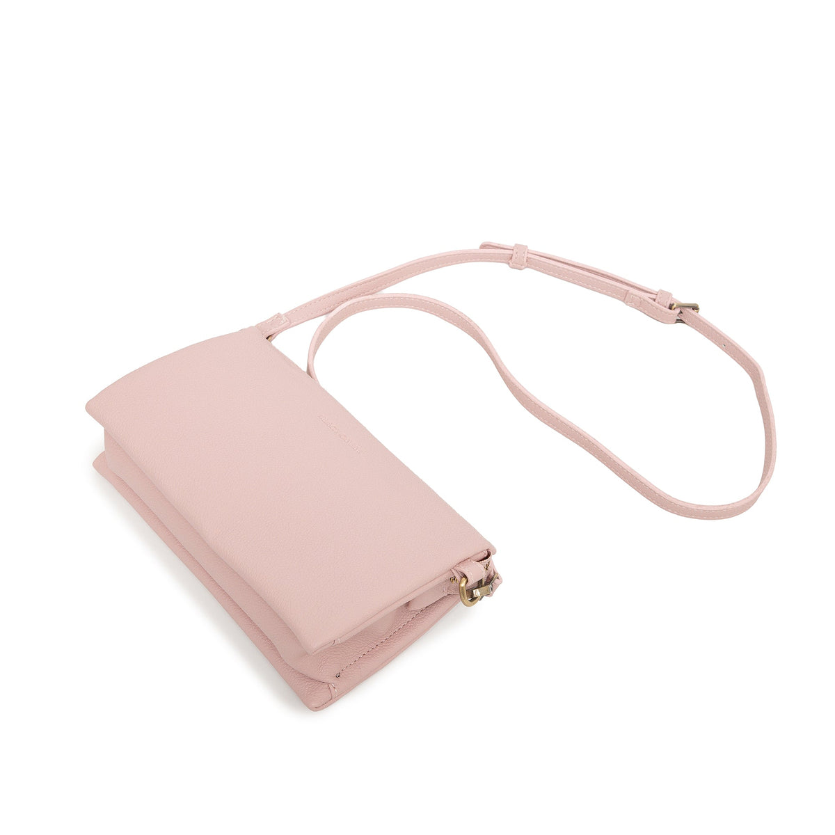 The pink bag lying at an angle with the slim strap looped behind.