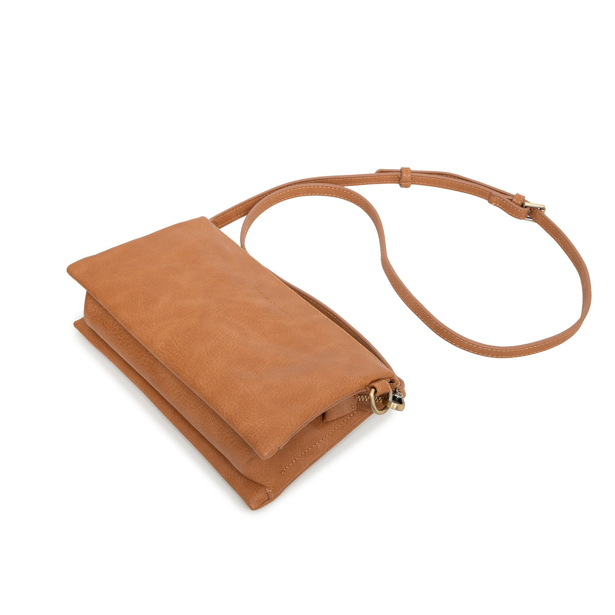 The tan bag lying at an angle with the slim strap looped behind.