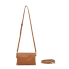 The tan bag on its slim adjustable strap.