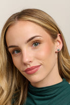 Model in a green top wearing the green gingham heart studs