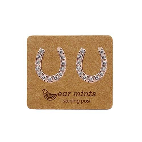 Pair of rose gold-tone horseshoe stud earrings set with clear cubic zirconia, on an Ear Mints card.